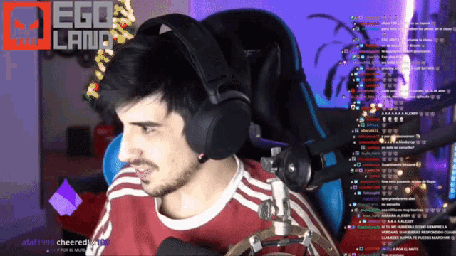 a man wearing headphones is sitting in front of a computer screen with ego land written on it