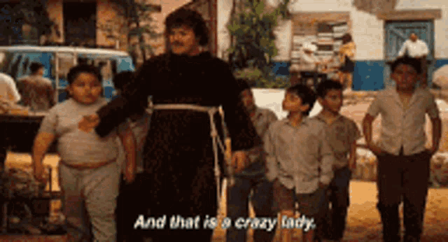 a group of children are standing around a man who says and that is a crazy lady ..