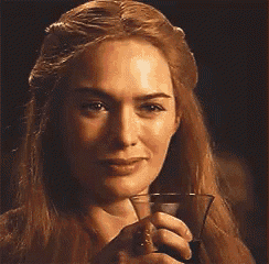 a woman with long blonde hair is holding a glass of wine in her hand .