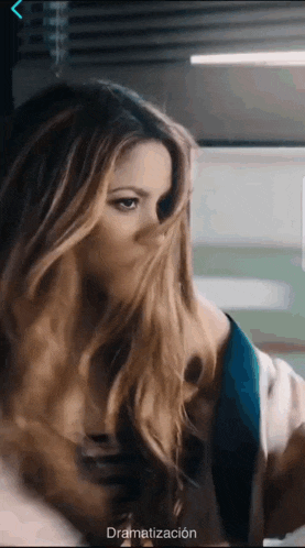 a woman 's face is covered by her hair and the word dramatización is on the bottom