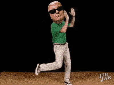 a man in a green shirt and white pants is dancing on a wooden floor .