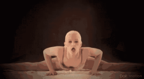 a woman in lingerie is doing a split on a bed