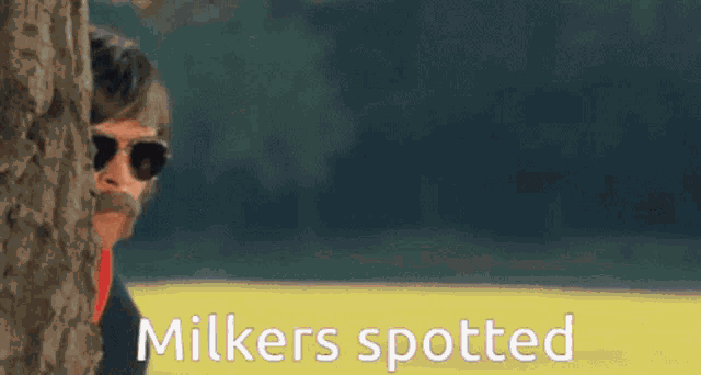 a man peeking out from behind a tree with the words " milkers spotted " written on the bottom