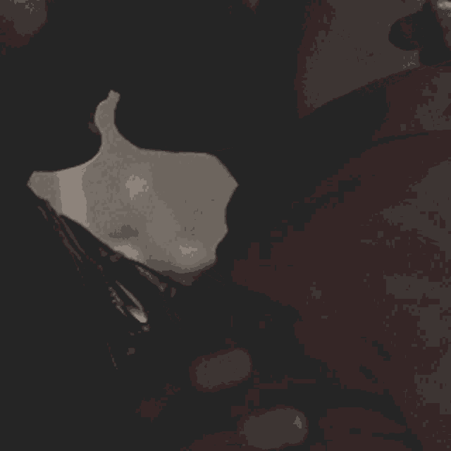 a man in a red shirt is kissing another man in the dark