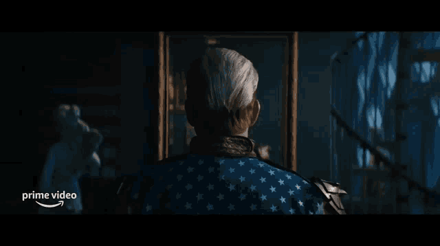 a man in an american flag outfit is looking at a mirror .