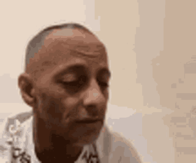 a close up of a man 's face with his eyes closed and a serious look on his face .