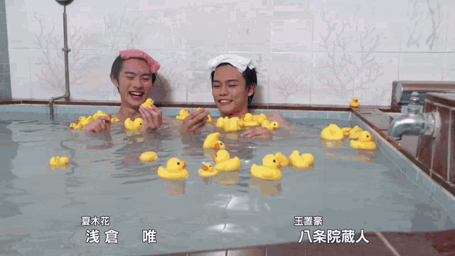 two men in a bathtub with rubber ducks