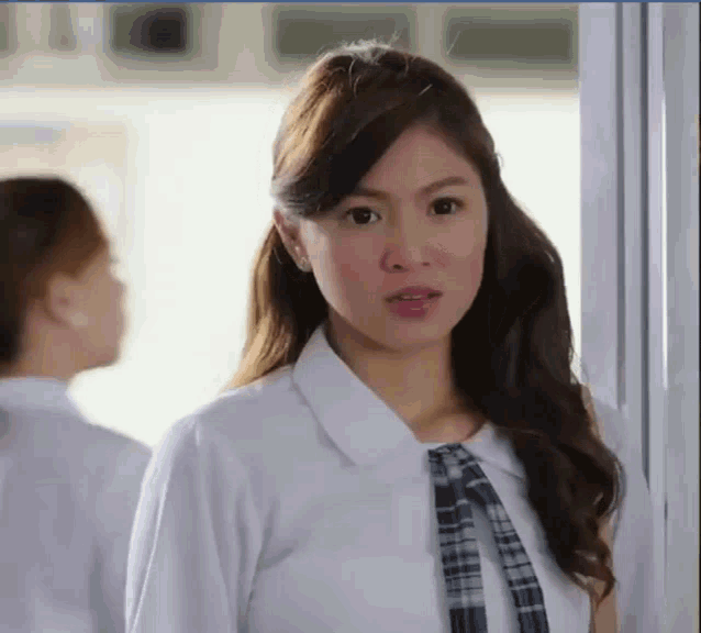 a woman in a white shirt and plaid tie