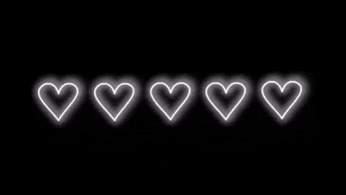 four white hearts are glowing in the dark on a black background .
