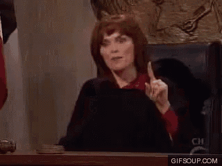a woman in a judge 's chair is pointing at the camera .