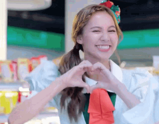 a girl making a heart with her hands and smiling