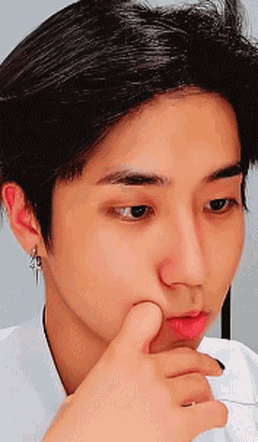 a close up of a person 's face with their hand on their face