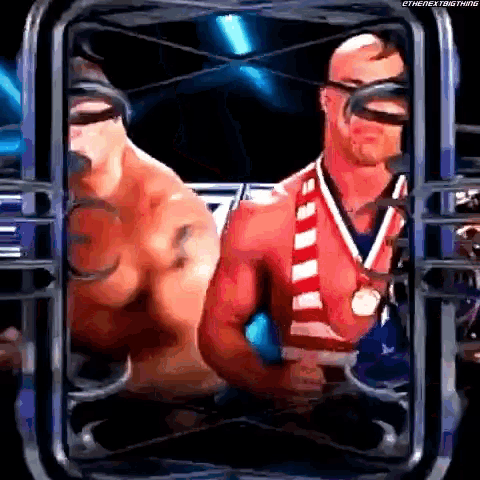 a man with a medal around his neck is standing next to another man in a cage .
