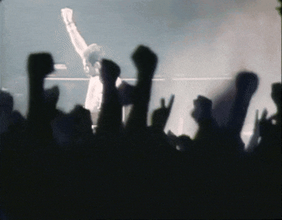 a crowd of people with their fists in the air