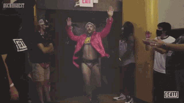 a man in a red jacket giving a thumbs up