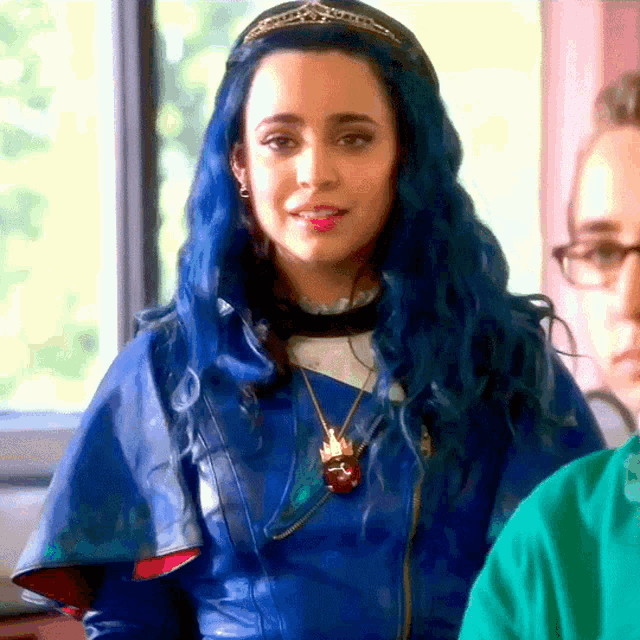 a woman with blue hair is wearing a tiara and a blue jacket