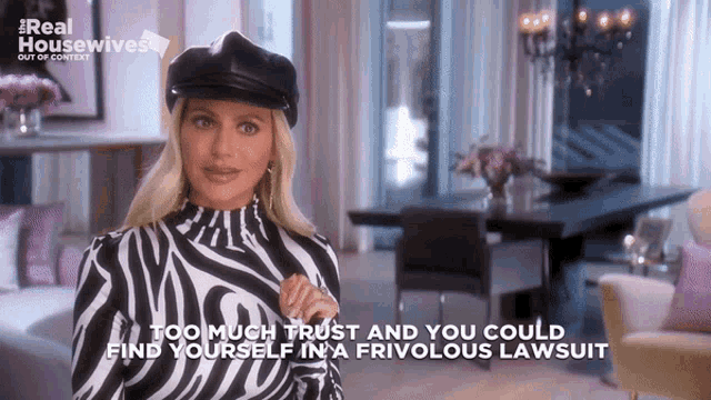 a woman is wearing a zebra print top and a black hat and says too much