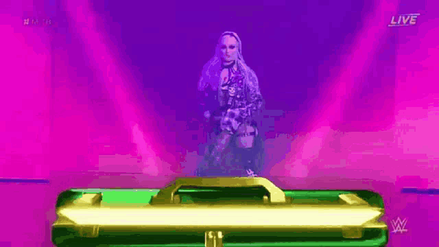 a woman is standing in front of a green briefcase in a purple and pink room .