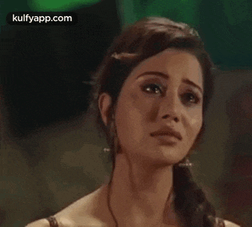 a close up of a woman 's face with tears coming out of her eyes .