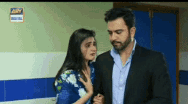 a man and woman are standing next to each other in a bathroom .