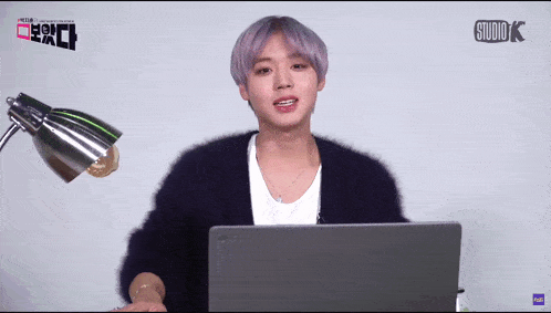a person sitting in front of a laptop with studio k written on the bottom right