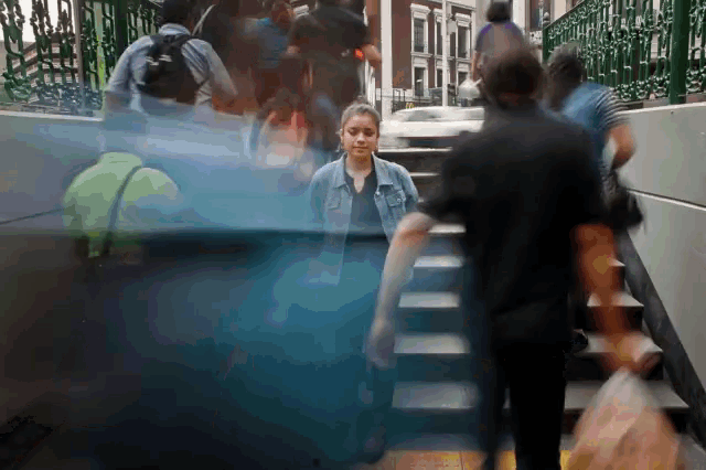 a blurry picture of people walking down stairs with a woman in the foreground