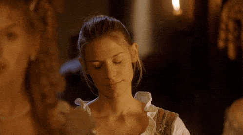a woman with her eyes closed and a ponytail