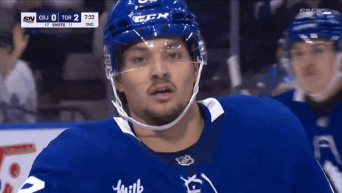 a hockey player wearing a blue helmet with the letter b on it