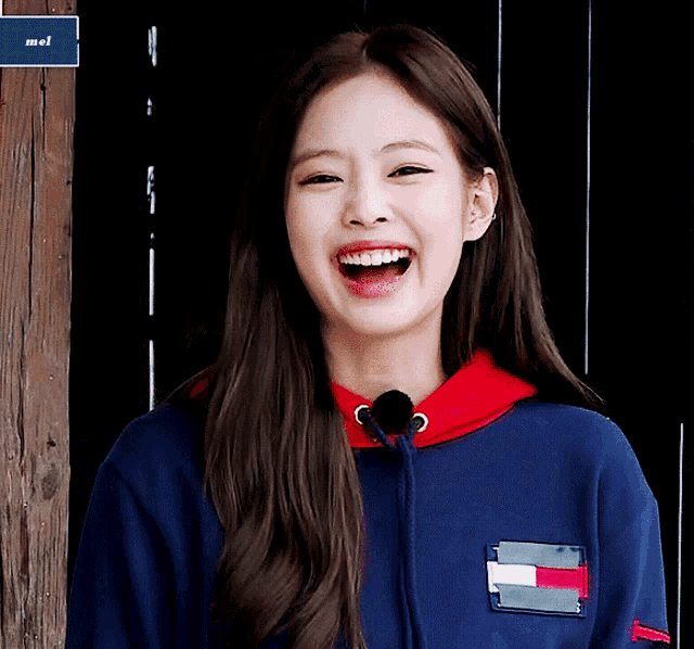 a girl wearing a blue tommy hilfiger sweatshirt smiles with her mouth open