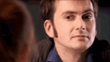 a close up of a man 's face making a funny face while looking at the camera .
