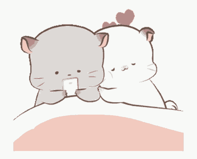 a couple of cats are laying on a bed and one is holding a cell phone