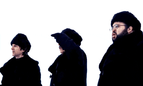 three men wearing black hats and coats are standing in the snow