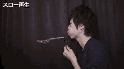 a man is blowing soap bubbles out of a straw .