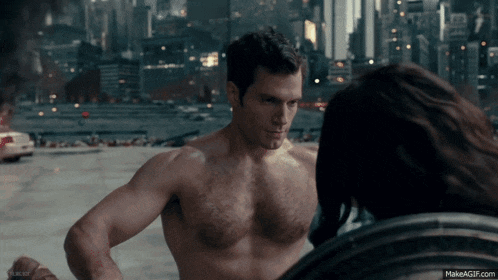 a shirtless man is standing next to a woman in front of a city skyline