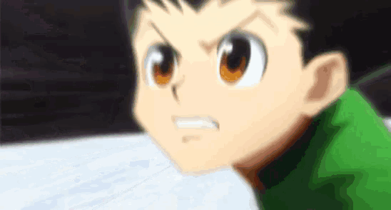 a close up of a cartoon character 's face with a green shirt and orange eyes .