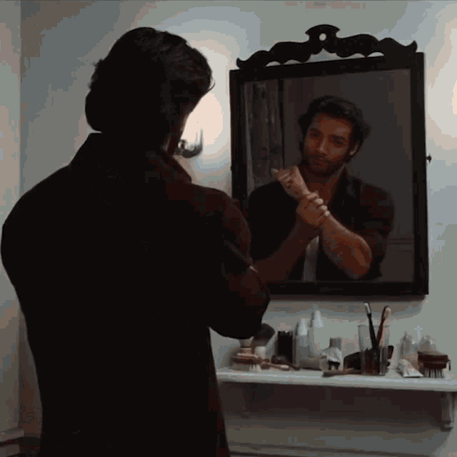 a man looks at his reflection in a mirror