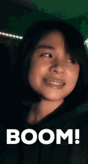a girl with braces on her teeth is smiling with the words boom written on the bottom .