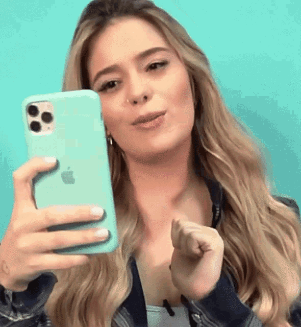 a woman is taking a picture of herself with an apple phone