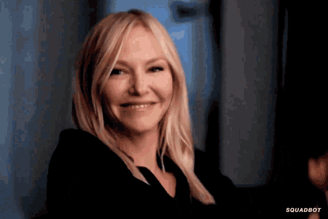 a woman in a black shirt is smiling with the words squadbot visible in the corner