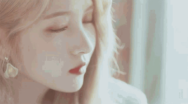a close up of a woman 's face with a blurred background and the words ' a woman ' on it