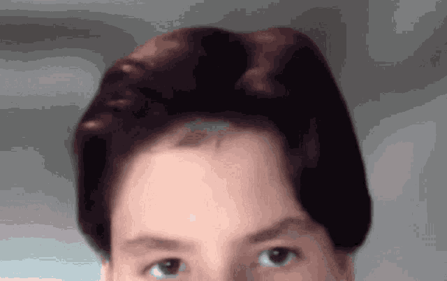 a close up of a person 's face with their eyes looking at the camera
