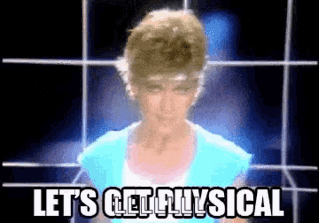 a woman in a blue shirt is standing in front of a screen with the words `` let 's get physical '' .
