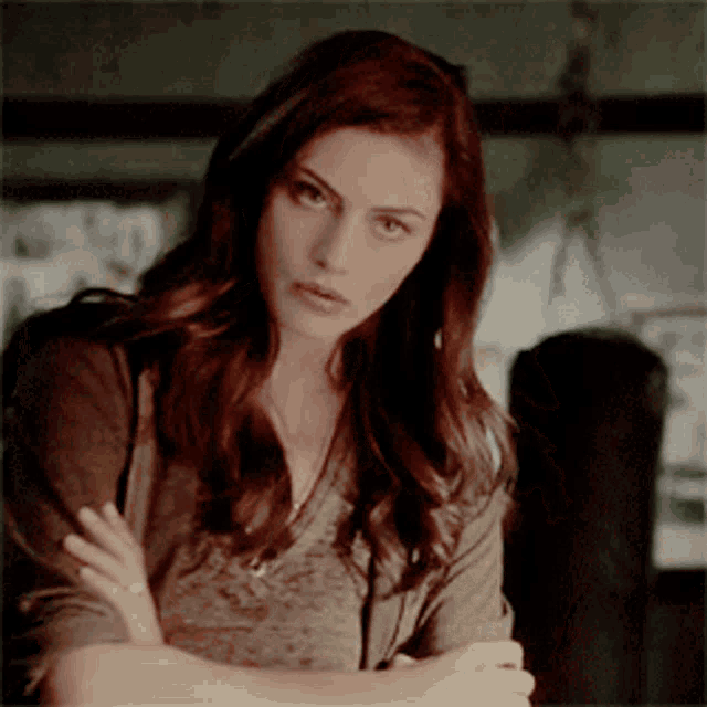 a woman with her arms crossed looking at the camera
