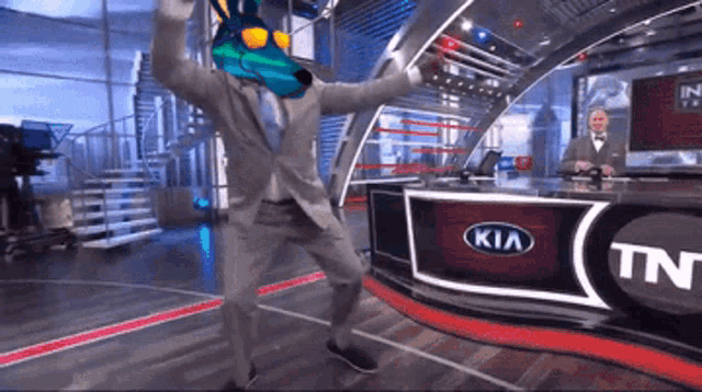 a man dancing in front of a kia sign