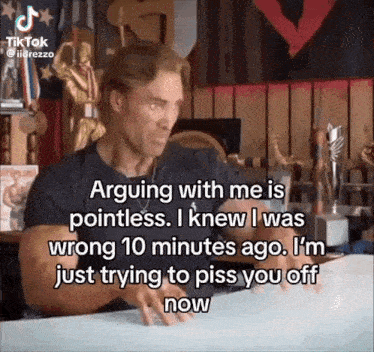 a man is sitting at a table with a caption that says " arguing with me is pointless