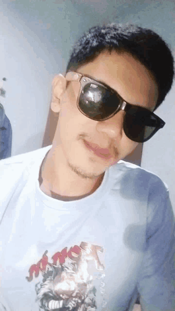a man wearing sunglasses and a shirt that says ' sniper ' on it