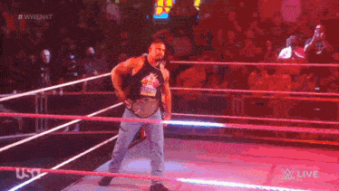a man in a tank top is standing in a wrestling ring with the word usa on the bottom right