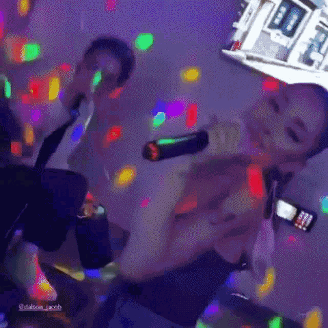 a woman is singing into a microphone in a dark room surrounded by lights .