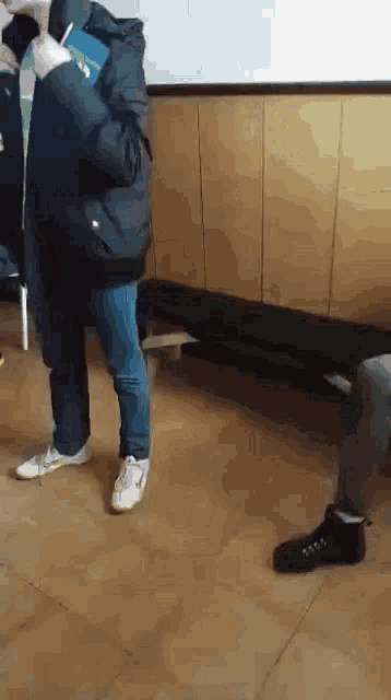 a man in a black jacket is standing on a tiled floor