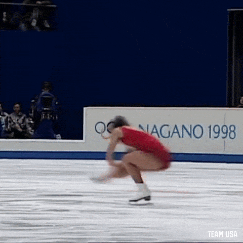 a woman is ice skating on a rink with a sign that says nagano 1998 .